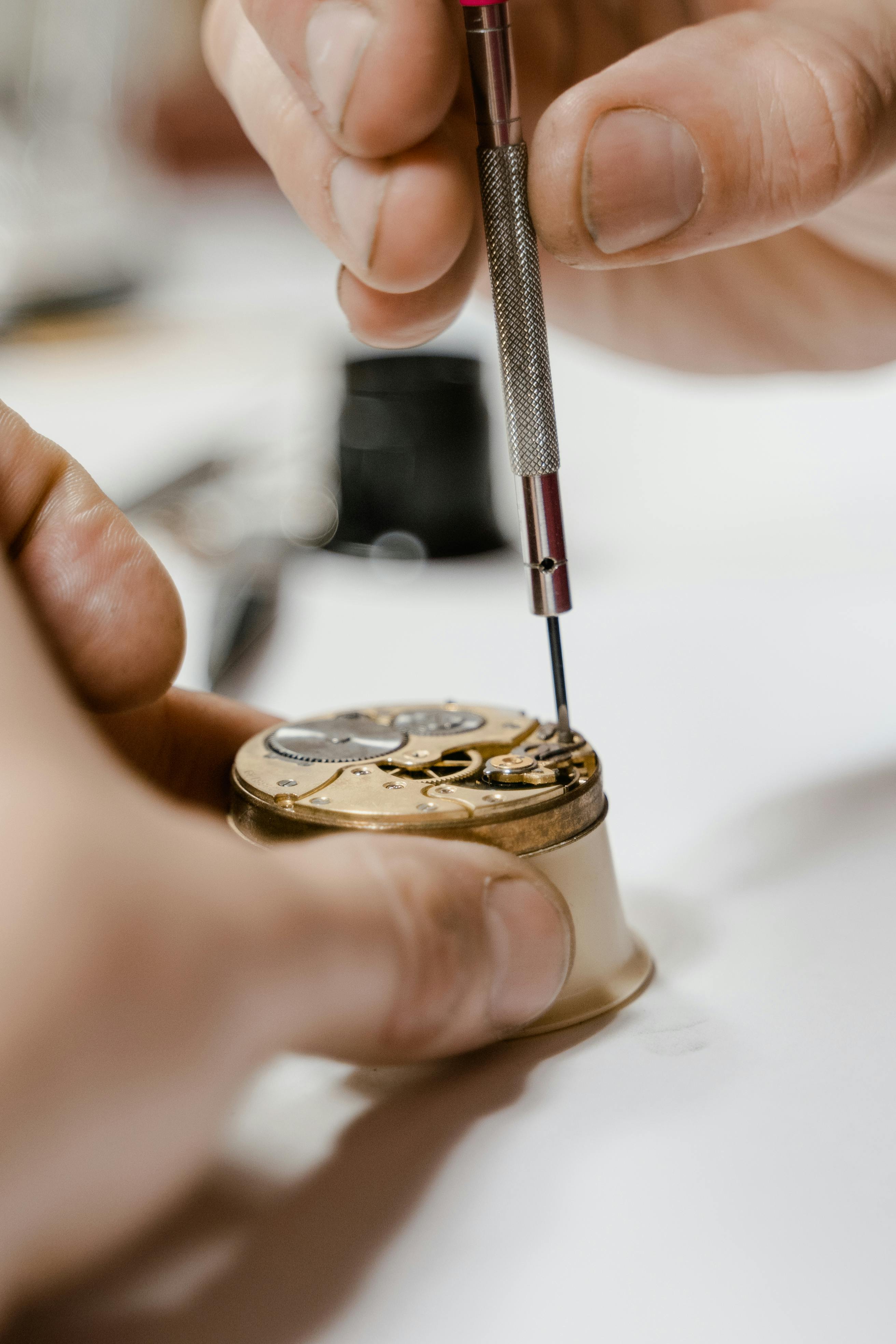 Uhrmacherwerkzeug und geöffnete mechanische Uhr auf der Werkbank