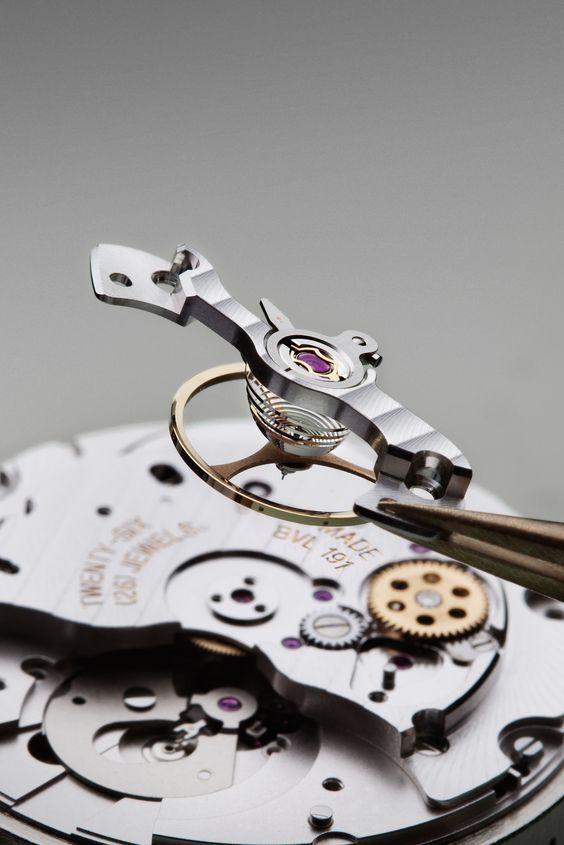 Kupferfarbene Zahnräder und smaragdgrüner Hintergrund einer mechanischen Uhr